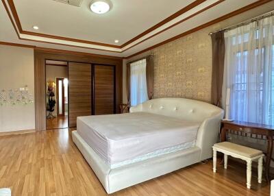 Spacious master bedroom with wood flooring and large bed