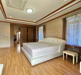 Spacious master bedroom with wood flooring and large bed