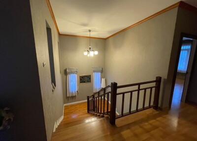 Spacious upper floor hallway with elegant lighting and wooden banister