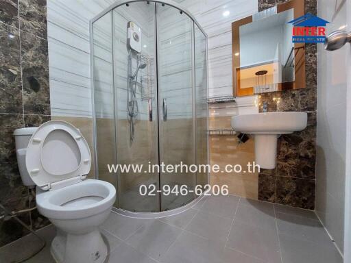 Modern bathroom with enclosed glass shower, toilet, and sink