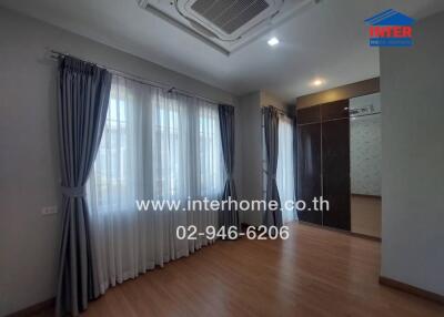 Spacious bedroom with ample natural light and modern air conditioning