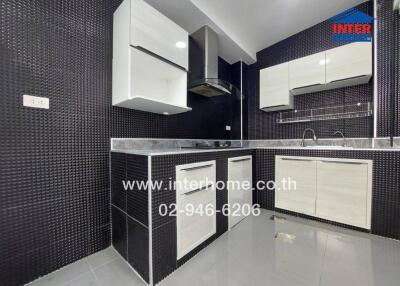 Modern kitchen with black and white cabinetry and advanced appliances