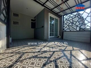 Spacious tiled balcony with glass door and geometric pattern floor