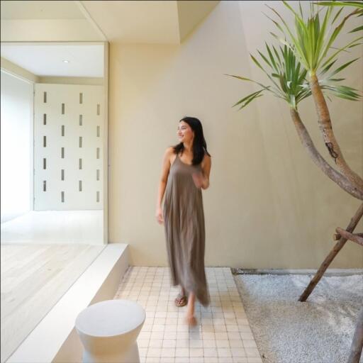 Woman walking in a modern, airy living space with stylish decor