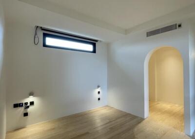 Minimalist bedroom with hardwood floors and modern lighting