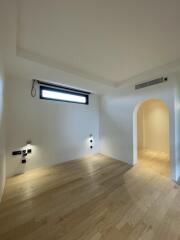 Minimalist bedroom with hardwood floors and modern lighting