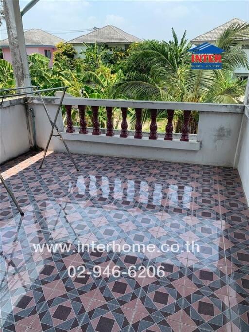 Spacious tiled balcony with decorative railing overlooking neighboring houses