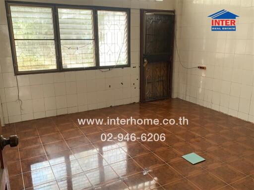 Spacious kitchen with large windows and tiled flooring