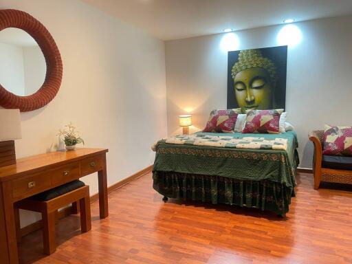 Spacious bedroom with Buddha artwork and hardwood flooring