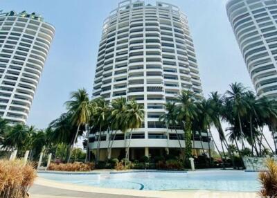 Modern high-rise residential building with swimming pool and palm trees