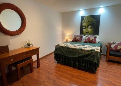 Elegant bedroom with Buddha wall art and hardwood flooring