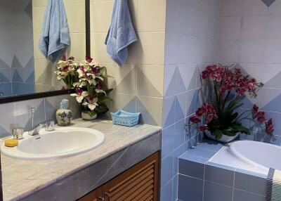 Elegant bathroom with blue tile decor and flower arrangements