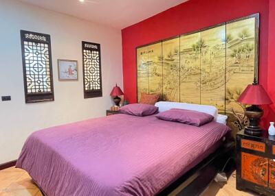 Vibrant Asian-inspired bedroom with decorative wall art and rich color palette