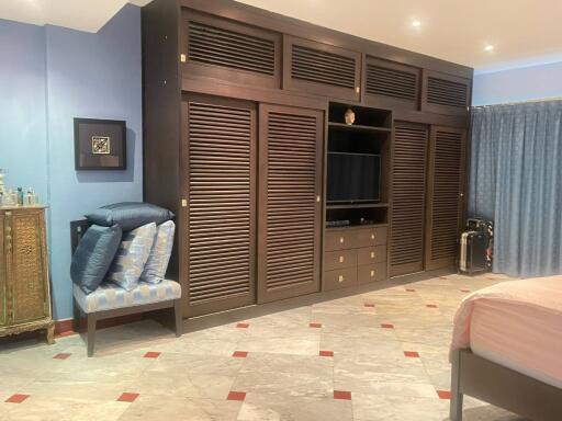 Spacious bedroom with large built-in wardrobe and tiled flooring