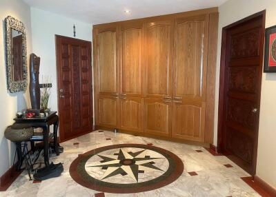 Spacious hallway with decorative marble floor and wooden cabinets