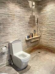 Modern bathroom with textured stone walls and integrated shower system