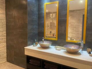 Modern bathroom with dual vessel sinks and decorative lighting