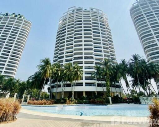 Luxurious high-rise residential buildings with a large swimming pool surrounded by palm trees