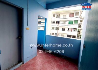 Compact balcony with blue walls and a view of neighboring buildings