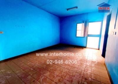 Spacious bedroom with bright blue walls and tiled flooring