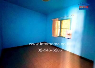 Bright blue empty bedroom with a single window and yellow curtains