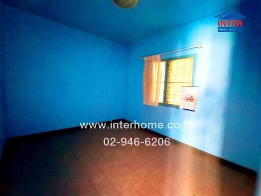 Bright blue empty bedroom with a single window and yellow curtains