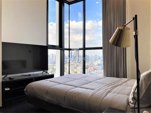 Modern bedroom with large windows overlooking the city