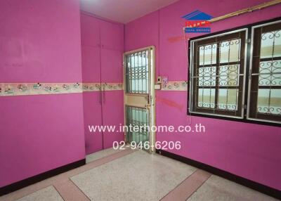 Vibrant pink bedroom with ceramic floor tiles and secure window grills