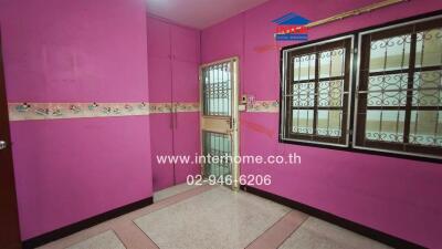 Vibrant pink bedroom with ceramic floor tiles and secure window grills