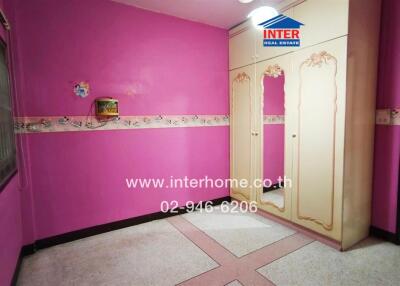 Bright pink bedroom interior with decorative wall trim and patterned flooring