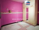 Bright pink bedroom interior with decorative wall trim and patterned flooring