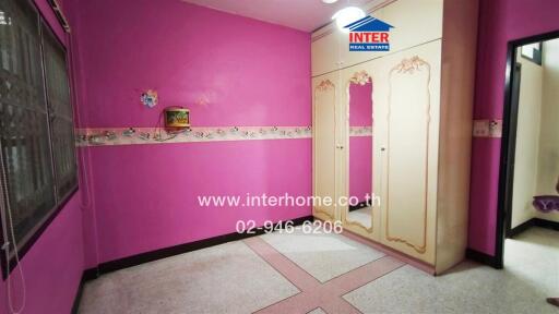 Bright pink bedroom interior with decorative wall trim and patterned flooring