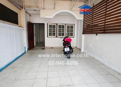 Spacious covered patio with tiled flooring and arched entryway