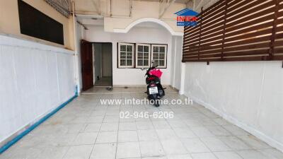 Spacious covered patio with tiled flooring and arched entryway