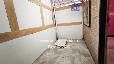 Empty storage room with wooden shelves and cement flooring