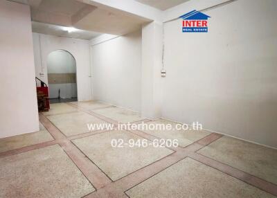 Spacious empty room with tiled flooring and white walls