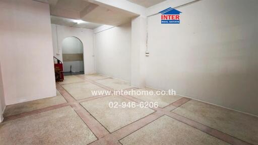 Spacious empty room with tiled flooring and white walls