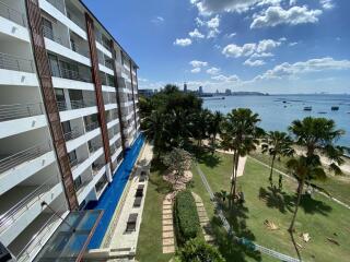 View of the building exterior with ocean view and lush green landscape