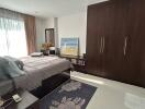Spacious and well-lit bedroom with large bed and wooden wardrobe