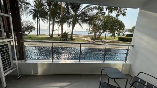 Spacious balcony overlooking a swimming pool and the beach