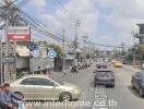 Busy urban street with various vehicles and commercial shops