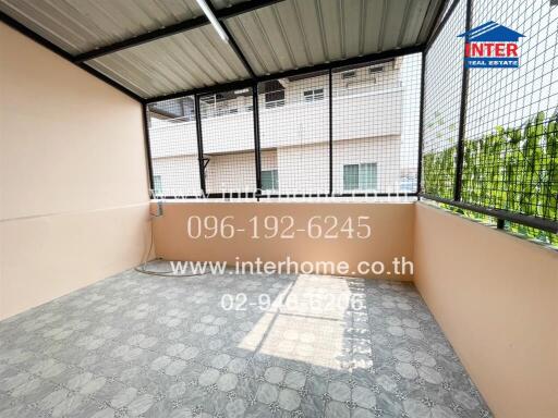 Spacious covered balcony with tiled floor and protective railing
