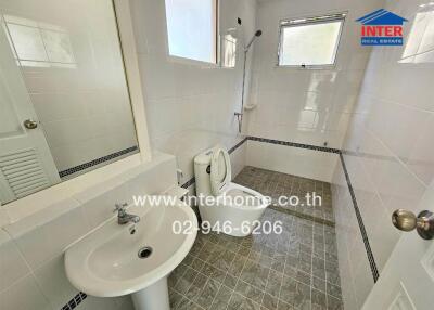 Modern bathroom with clean white fixtures and grey tiled floor