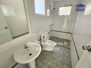 Modern bathroom with clean white fixtures and grey tiled floor