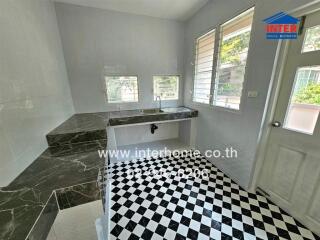 Modern kitchen with marble countertops and checkered floor