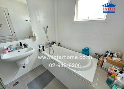 Spacious white bathroom with bathtub and sink