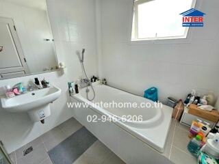 Spacious white bathroom with bathtub and sink