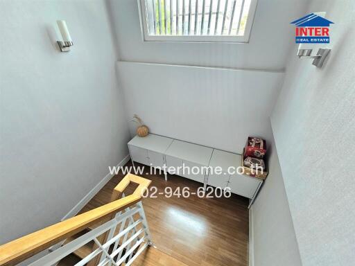 Bright and modern staircase landing with storage cabinets