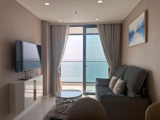 Cozy living room with ocean view, modern furnishings, and large windows