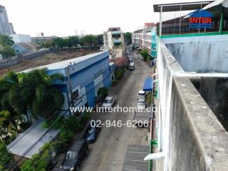 Urban street view from the balcony showing buildings and parked cars